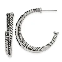 A pair of silver-toned hoop earrings with twisted rope texture and black gemstone accents along the outer edge, shown from front and side views.