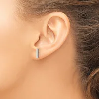 A person wearing a small rectangular silver bar stud earring in their earlobe, shown in profile view.
