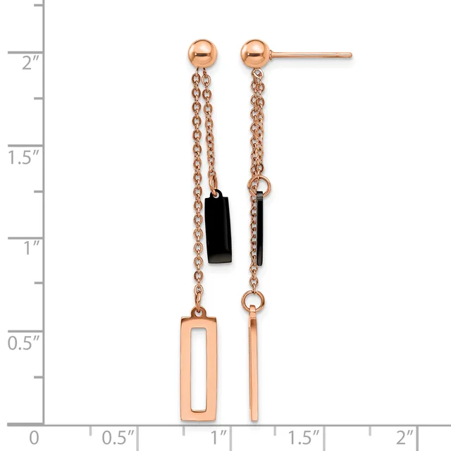 A pair of rose gold drop earrings with ball studs, delicate chains, a black rectangular stone on one side, and geometric rectangular cutout pendants, displayed against a measurement scale.