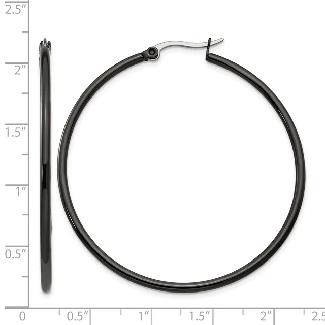 Two black metal hoop earrings displayed next to a ruler, showing the larger hoop measures approximately 2 inches in diameter and a smaller post earring measures about 2.25 inches in length.