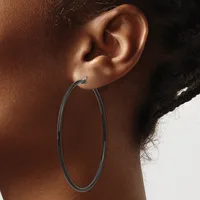 A person wearing a large oval hoop earring in dark metal, shown from the side profile against a neutral background.