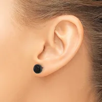 A person wearing a small round black stud earring in their earlobe, shown from the side profile.