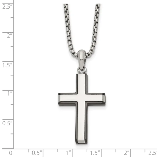 A stainless steel cross pendant with hollow rectangular arms hangs from a stainless steel chain, displayed against a measurement scale showing the pendant is approximately one inch wide and one and one-half inches tall.