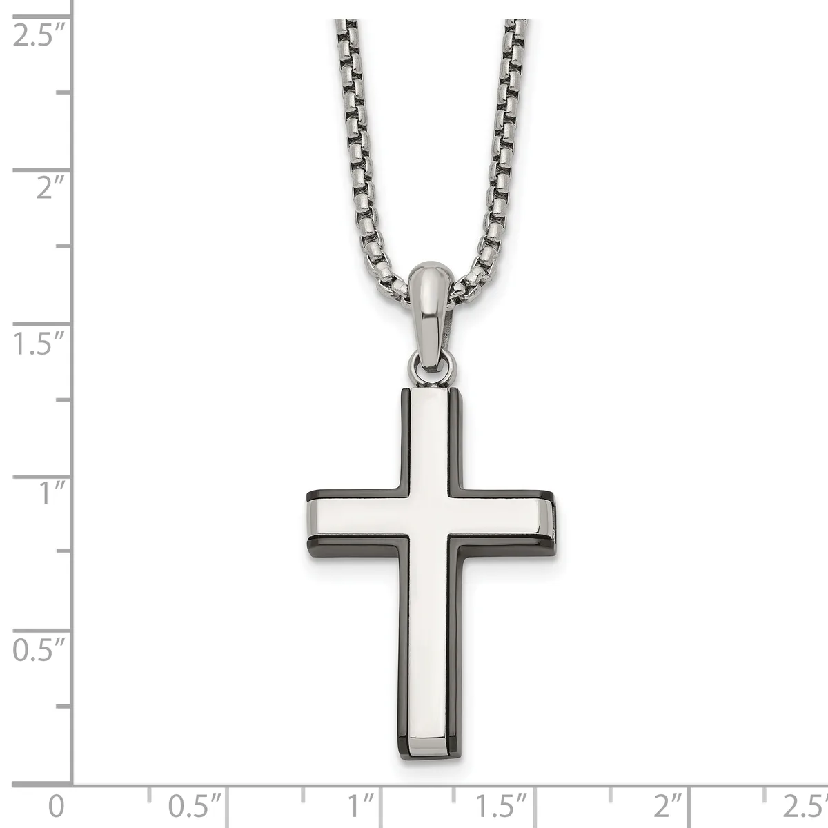 A stainless steel cross pendant with hollow rectangular arms hangs from a stainless steel chain, displayed against a measurement scale showing the pendant is approximately one inch wide and one and one-half inches tall.