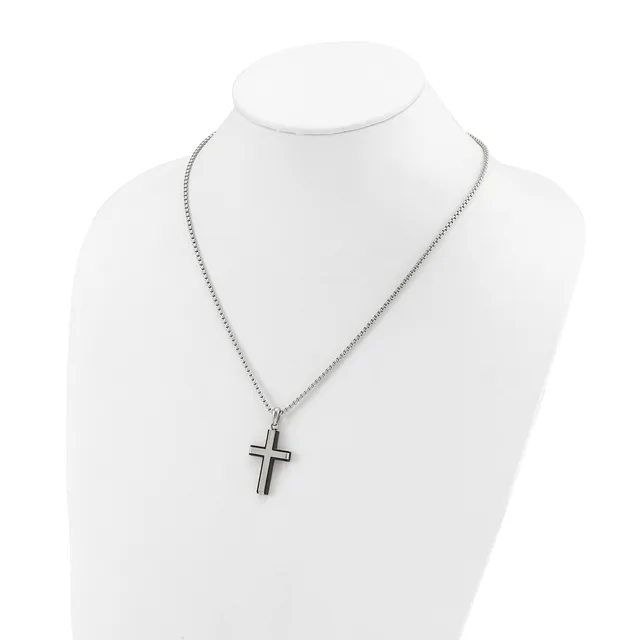 A silver-toned cross pendant hangs from a delicate chain on a white mannequin bust display.