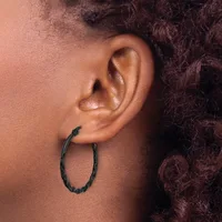 A person wearing a black textured hoop earring in their earlobe, shown in profile against their skin.