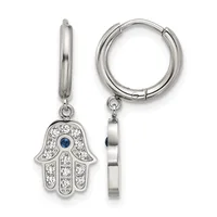 A pair of silver hoop earrings with hanging hamsa hand charms decorated with clear crystals and a small blue stone in the center.