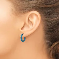 A person wearing a small blue hoop earring in their earlobe, shown from the side profile of their head and neck.