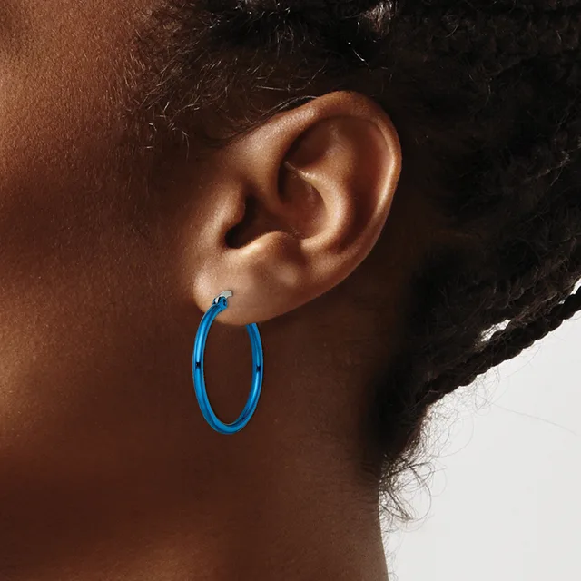 A person wearing a blue hoop earring is shown in profile, displaying the earring against their ear and neck.
