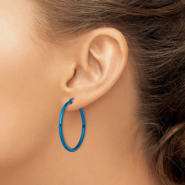 A person wearing a blue hoop earring in their earlobe, shown from the side profile view.