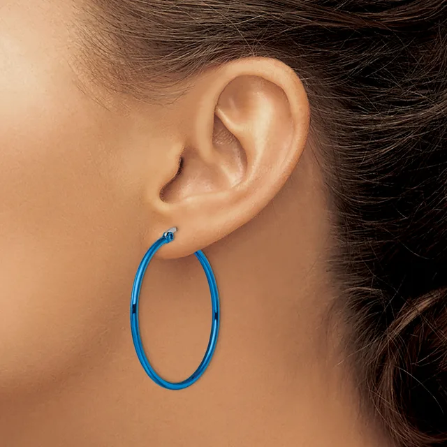 A blue hoop earring hanging from a pierced earlobe, shown in profile against skin tone.