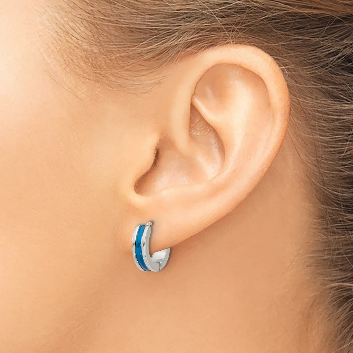 A person wearing a small hoop earring with a blue stripe detail on the outer curved surface, shown from a side profile view.