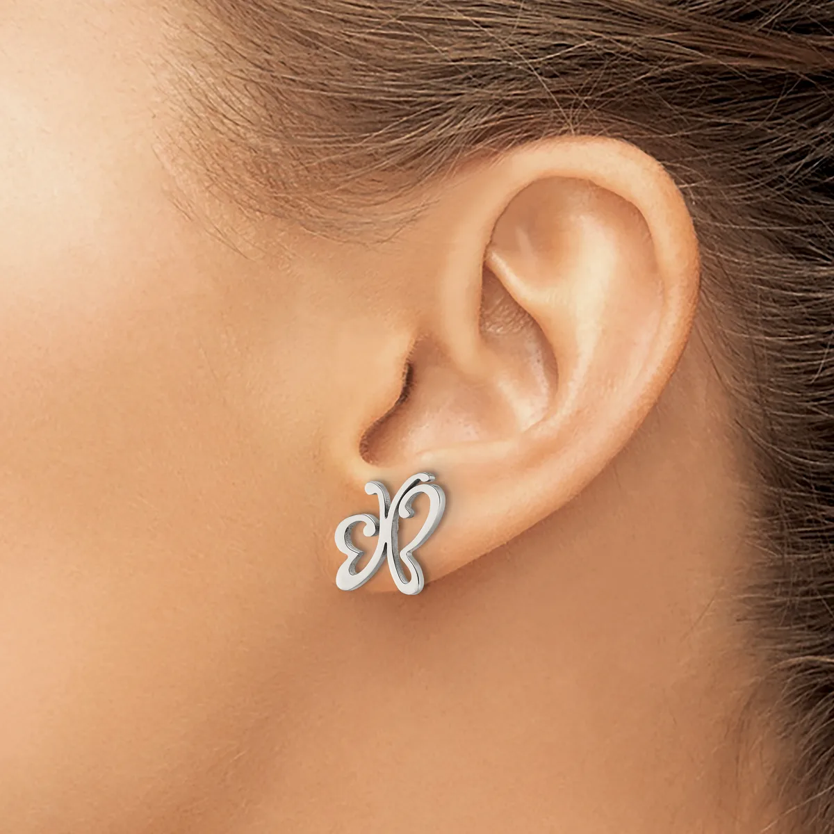 A silver butterfly-shaped stud earring worn on a person's earlobe, shown in profile against their neck and shoulder.