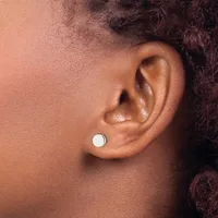 A person wearing a small white circular stud earring in their earlobe, shown in profile view.