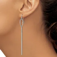 A woman wearing long silver-toned drop earrings with small oval loops at the top and straight rod stems extending downward.