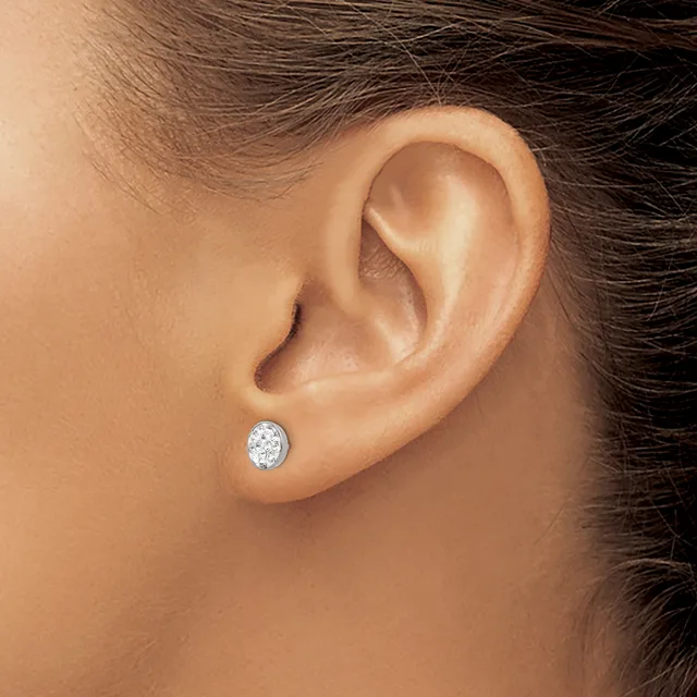 A person wearing a small oval diamond stud earring in their pierced earlobe, shown in profile view.