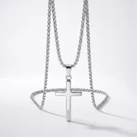 Silver-toned chain necklace with a polished cross pendant and matching decorative chain bracelet displayed on a white background.