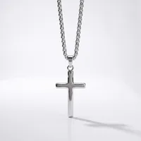 A polished silver cross pendant hangs from a matching chain against a white background, casting a soft shadow.