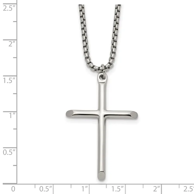 A polished silver cross pendant hanging from a box chain necklace, displayed against a ruler showing the cross is approximately one inch wide and two inches tall.