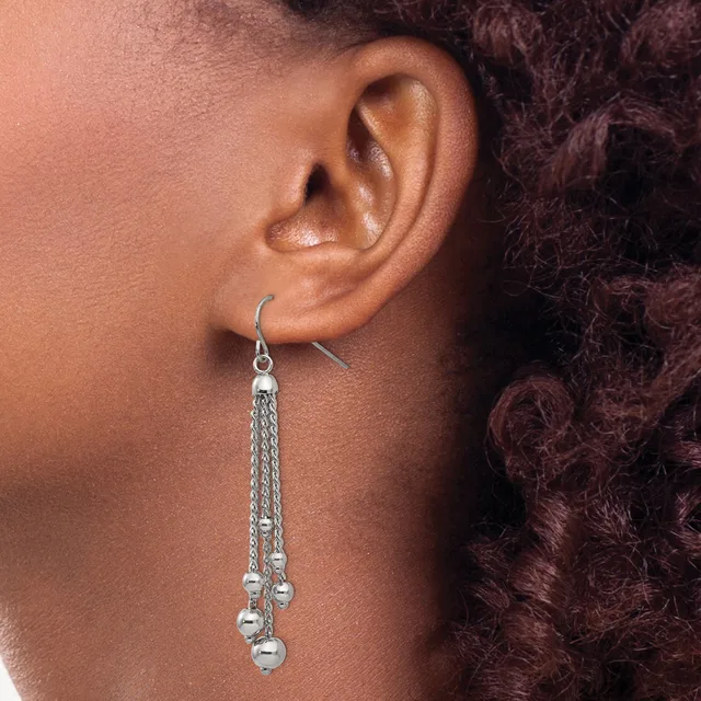 A silver chain dangle earring with small spherical beads hanging from the end, worn on a pierced ear.