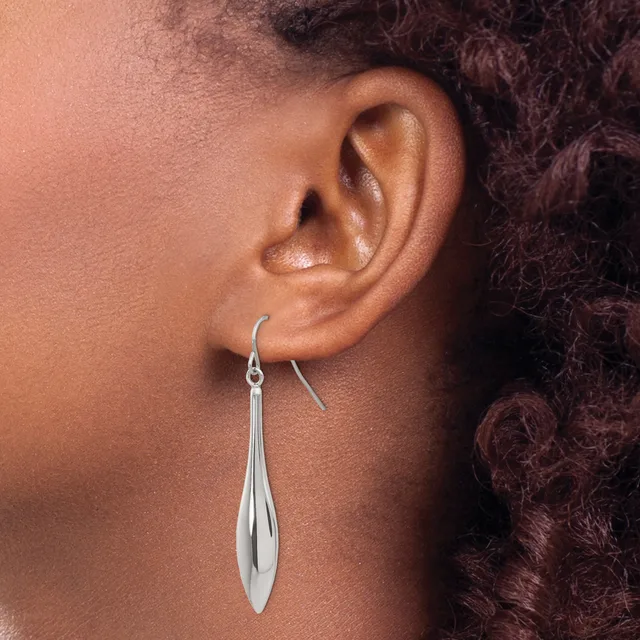 A person wearing a long, polished silver teardrop-shaped earring on a hook, shown in profile against their neck and shoulder.