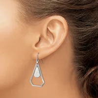 A person wearing a silver geometric teardrop-shaped dangle earring with a hollow pentagonal outline, shown from the side view of their ear.