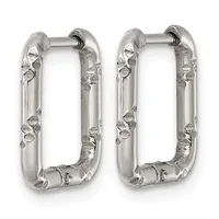 A pair of silver rectangular hoop earrings with textured surfaces featuring small circular and geometric embellishments along the sides.