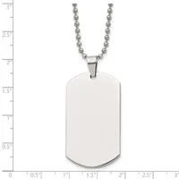 A stainless steel dog tag pendant with rounded corners hangs from a ball chain, displayed against a ruler showing the tag is approximately 1.25 inches tall and 0.75 inches wide.