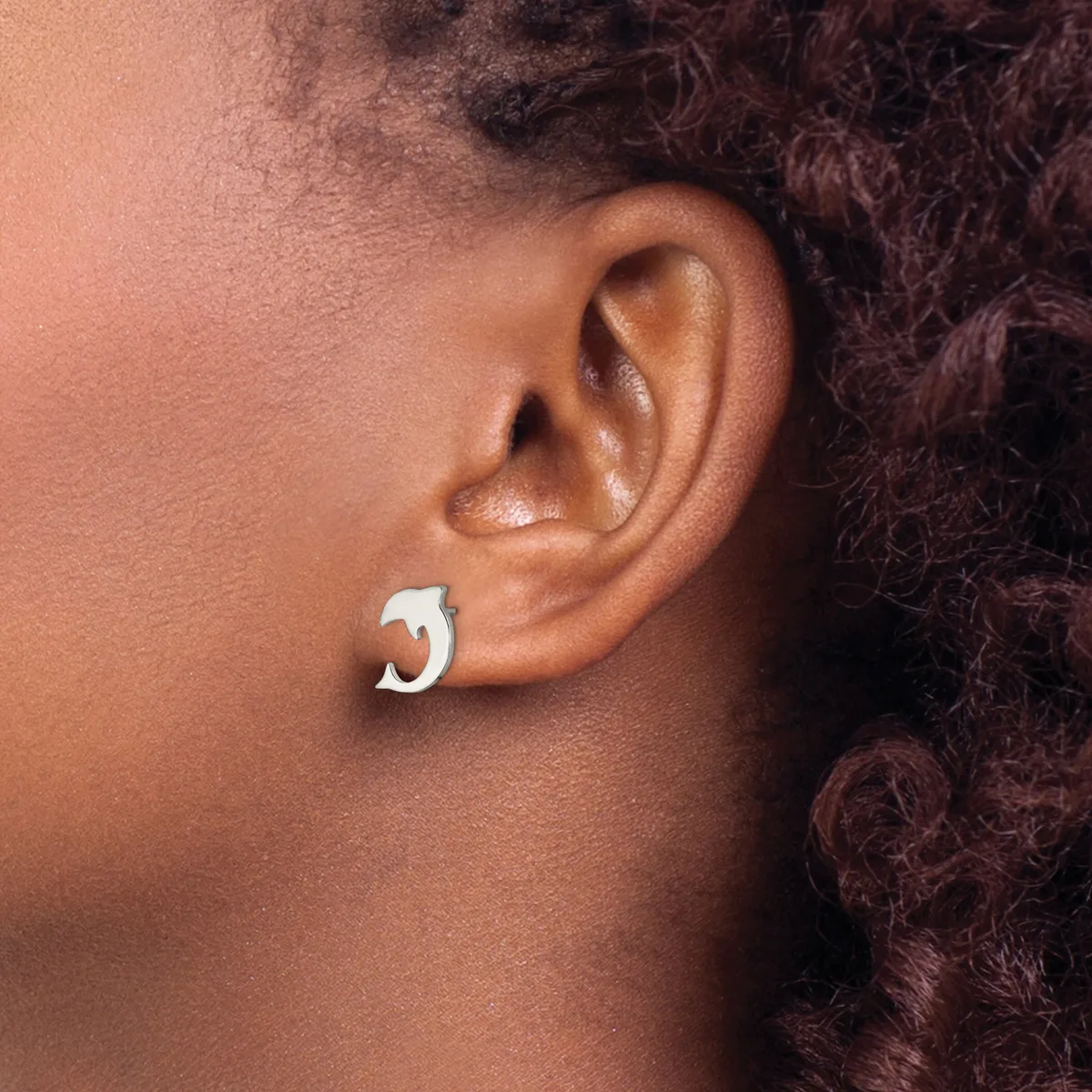 A person wearing a silver chunky curved hoop earring in their earlobe, shown in profile against their shoulder.