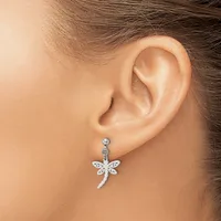 A person wearing a silver dragonfly pendant earring with textured wings hanging from a small round stud on their earlobe.