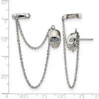 Silver ear cuff pair with dangling chain and skull charms with blue stone eyes, displayed against a ruler showing approximately 2.5 inches in height.