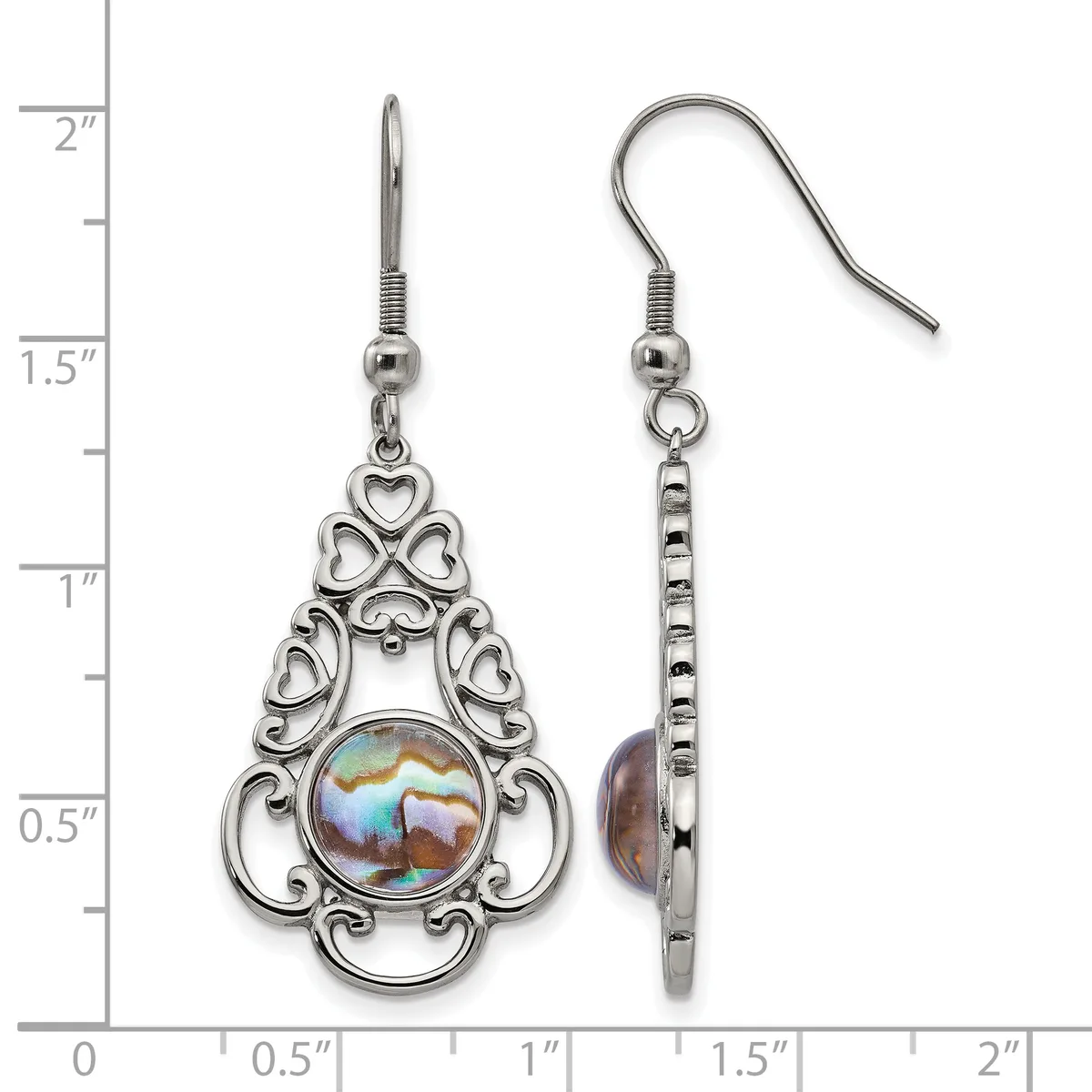A pair of ornate silver-toned drop earrings with filigree heart designs and iridescent abalone shell centers, displayed on a measurement scale.
