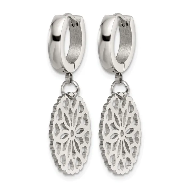 A pair of silver huggie hoop earrings with ornate oval filigree pendants featuring a floral cutout design.