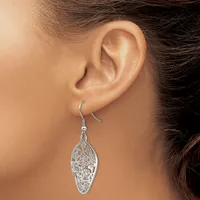 A woman wearing a silver filigree leaf-shaped dangle earring with an ornate cutout pattern, shown from the side view of her ear and face.