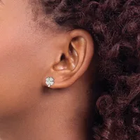 A person wearing a four-leaf clover shaped earring stud with white mother-of-pearl in their pierced ear lobe.