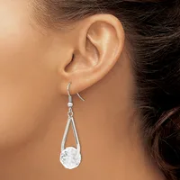 A woman wearing a teardrop-shaped silver dangle earring with a clear crystal stone, shown from the side against her ear.