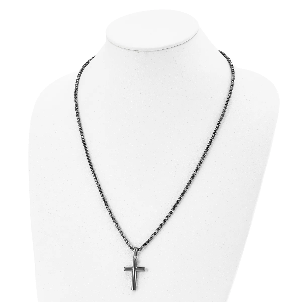 A stainless steel cross pendant hangs from a matching chain necklace, displayed on a white mannequin bust.
