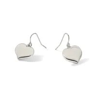 A pair of silver heart-shaped drop earrings with polished surfaces, suspended from curved wire hooks.