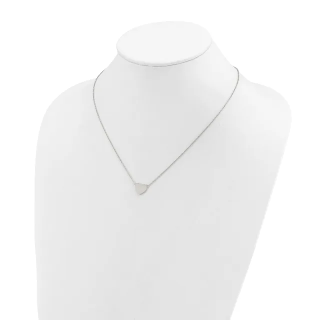 A delicate silver-toned necklace with a small triangular pendant displayed on a white mannequin bust.