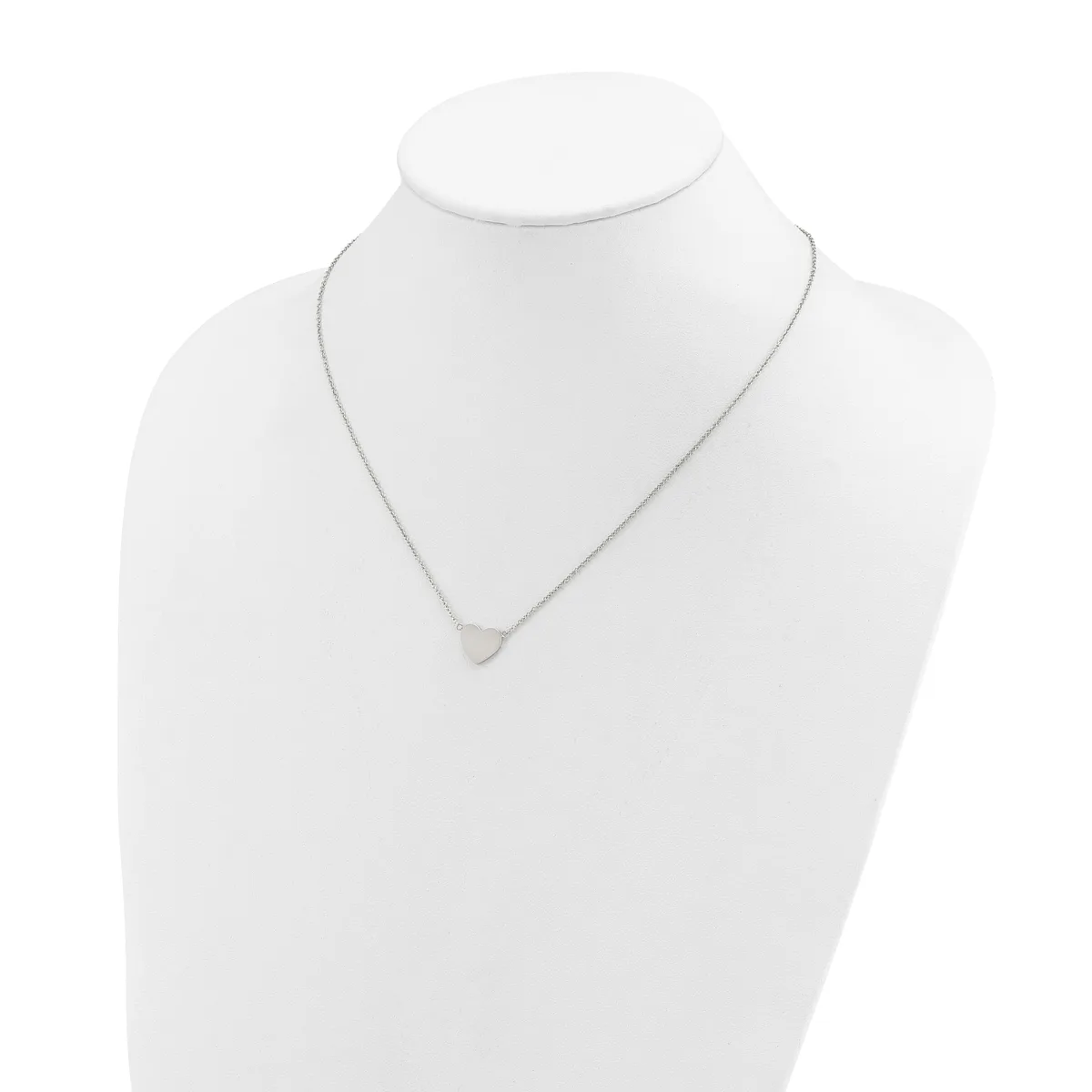 A delicate silver-toned necklace with a small triangular pendant displayed on a white mannequin bust.