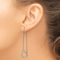 A person wearing a long silver chain threader earring with a small hexagonal pendant hanging from the end.