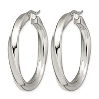 A pair of polished silver-toned hoop earrings with a chunky, tubular design and hinged closures, shown from above.