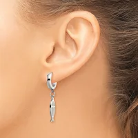 A person wearing a silver hoop earring with a small dangling fish charm, shown from the side view near the ear.