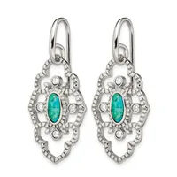 A pair of ornate silver drop earrings featuring turquoise oval stones surrounded by circular diamond accents and decorative filigree metalwork.
