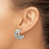 A woman wearing triple-band silver hoop earrings, shown from the side profile of her ear and neck.