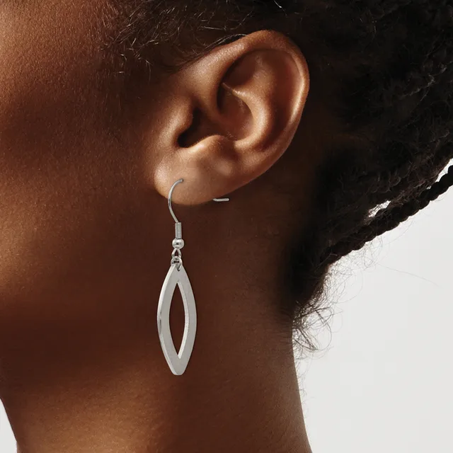 A person wearing a silver elongated oval drop earring with an open center, shown from the side profile against a neutral background.