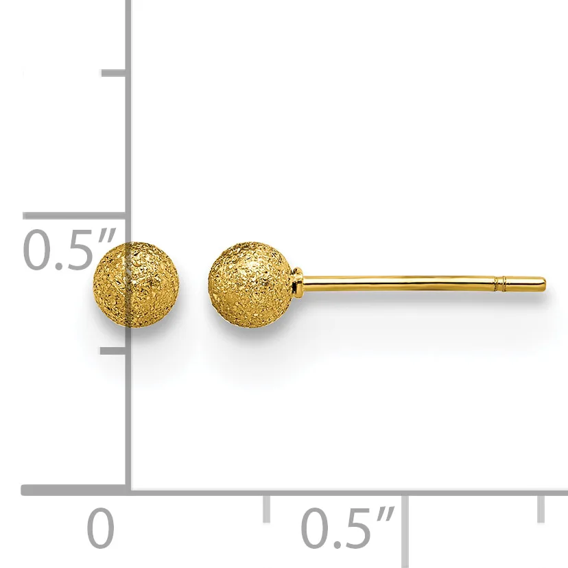 A pair of gold stud earrings with textured spherical heads next to a ruler showing them to be approximately 5mm in diameter.
