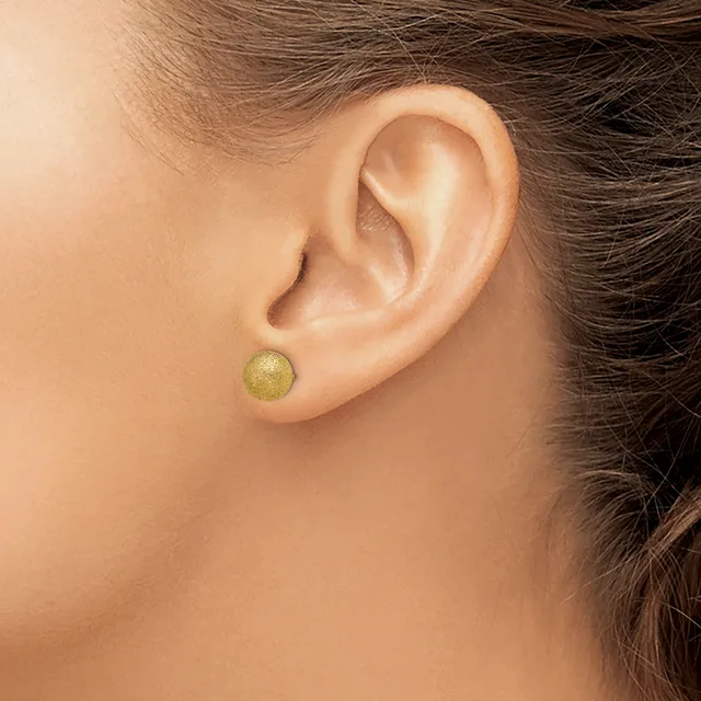 A person wearing a small round gold stud earring in their pierced earlobe, shown from the side profile.