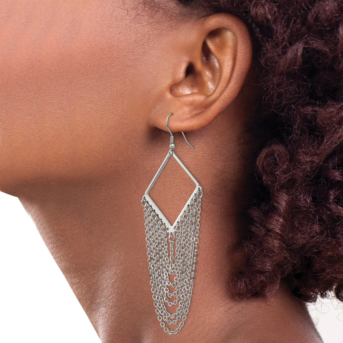 A person wearing a silver chandelier-style earring with a diamond-shaped top and multiple strands of chain hanging below, shown from the side profile.