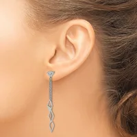 A woman wearing a long silver dangle earring with a twisted chain design and geometric pendant, shown from the side profile of her ear.